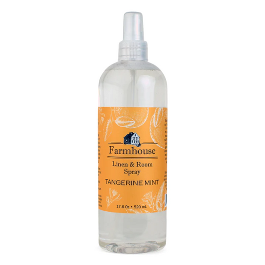 A clear spray bottle labeled 'Farmhouse Linen & Room Spray Tangerine Mint'.