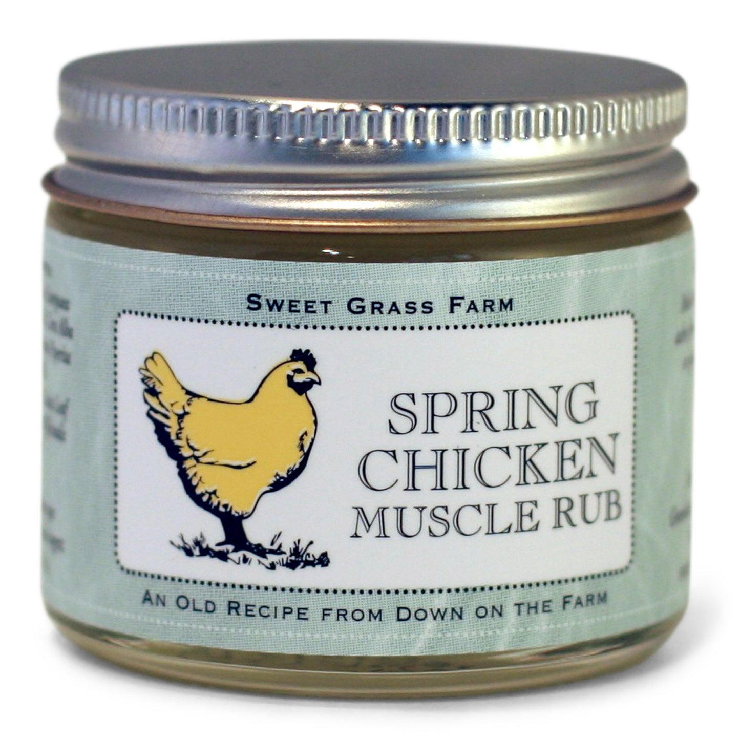 A glass jar with a metal lid labeled 'Spring Chicken Muscle Rub' from Sweet Grass Farm, featuring an illustration of a chicken.