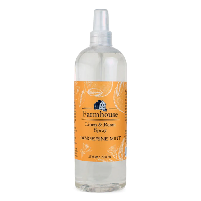 A clear spray bottle labeled 'Farmhouse Linen & Room Spray Tangerine Mint'.