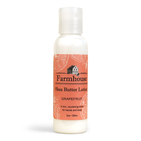 A mini bottle of Farmhouse Shea Butter Lotion with the label showing 'Grapefruit'.