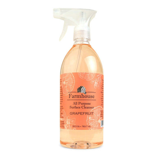A clear spray bottle labeled 'Farmhouse' with 'All Purpose Surface Cleanser' and 'Grapefruit' scent, containing a plant-based cleaner.