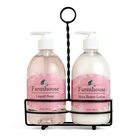 A black metal caddy holding two bottles, one labeled as 'Farmhouse Liquid Soap' and the other as 'Shea Butter Lotion', in Fresh White Lilac scent