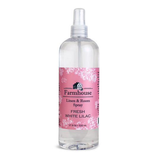 A clear spray bottle labeled 'Farmhouse Linen & Room Spray Fresh White Lilac'.