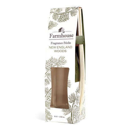 A package of Farmhouse Fragrance Sticks with a new england woods scent, featuring a square glass jar and rattan reeds.