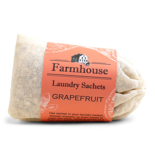 A bundle of beige linen sachets with an orange label that reads 'Farmhouse Laundry Sachets GRAPEFRUIT'.