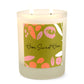 A white soy wax candle with a label that has 'Home Sweet Home' written on it and colorful abstract shapes.