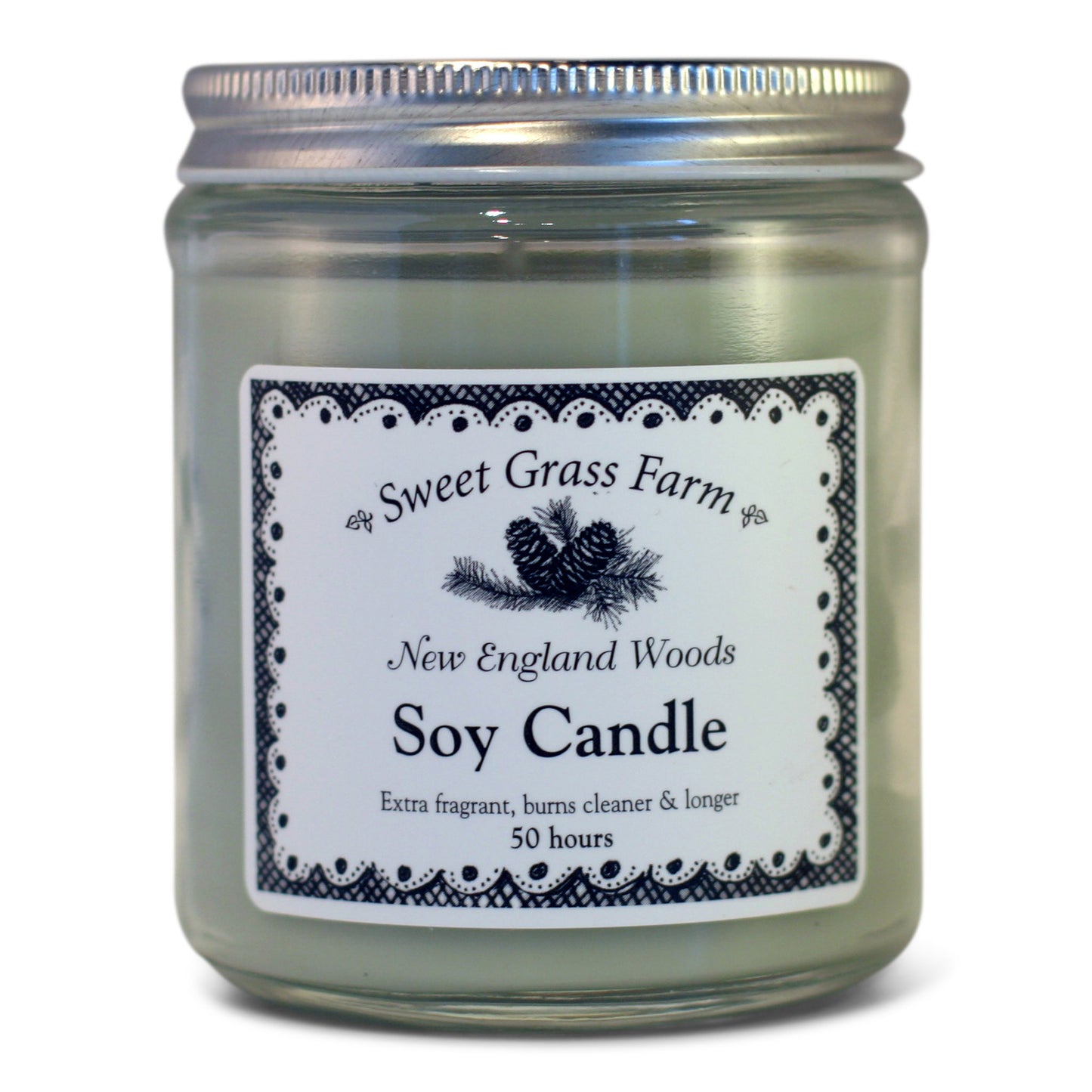 A soy wax candle in a clear glass jar with a label reading 'Sweet Grass Farm New England Woods Soy Candle', with a definition stating 'Extra fragrant, burns cleaner & longer 50 hours'.