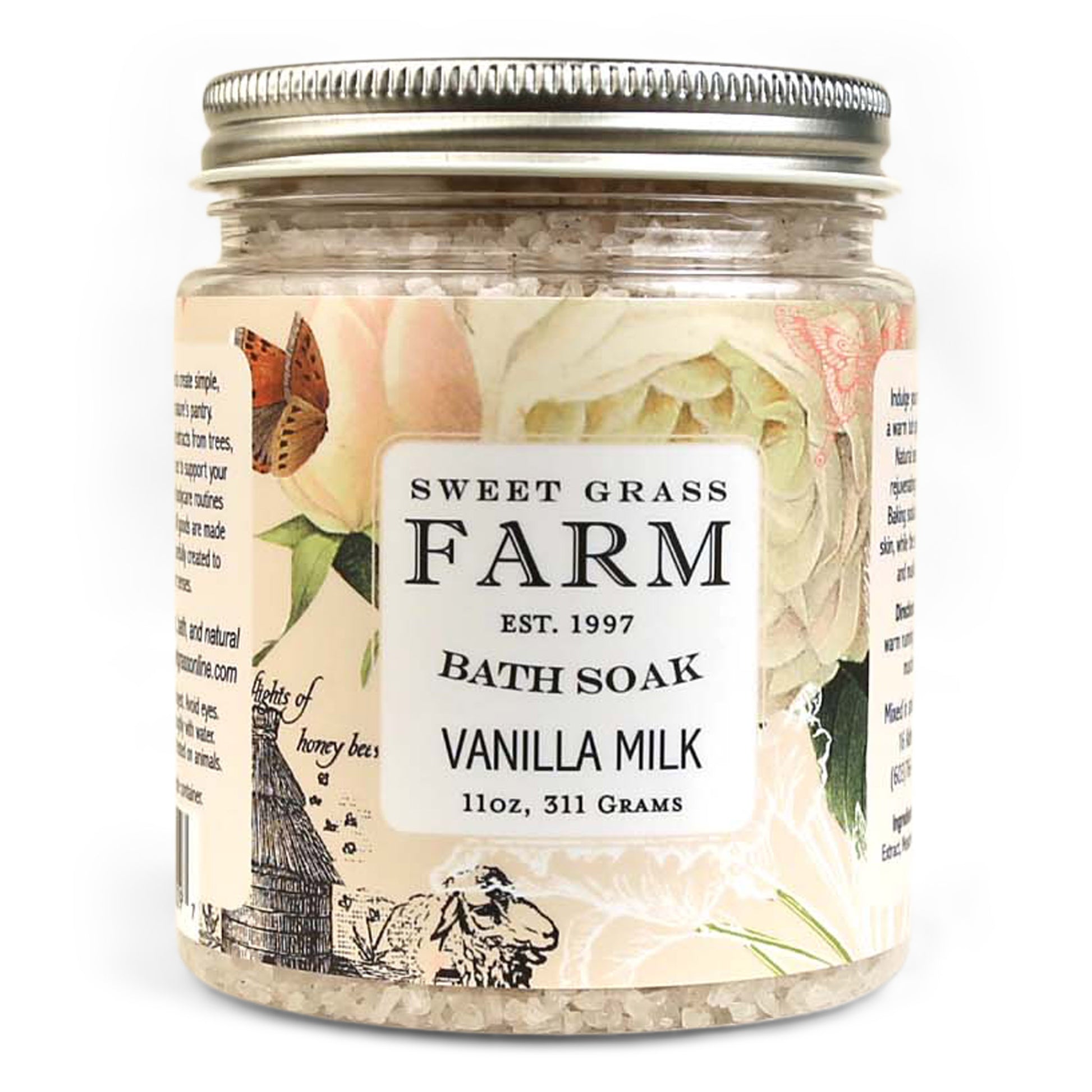 A jar of Sweet Grass Farm bath soak with a label that reads 'BATH SOAK VANILLA MILK 11oz, 311 Grams'. The jar is filled with beige bath salts.